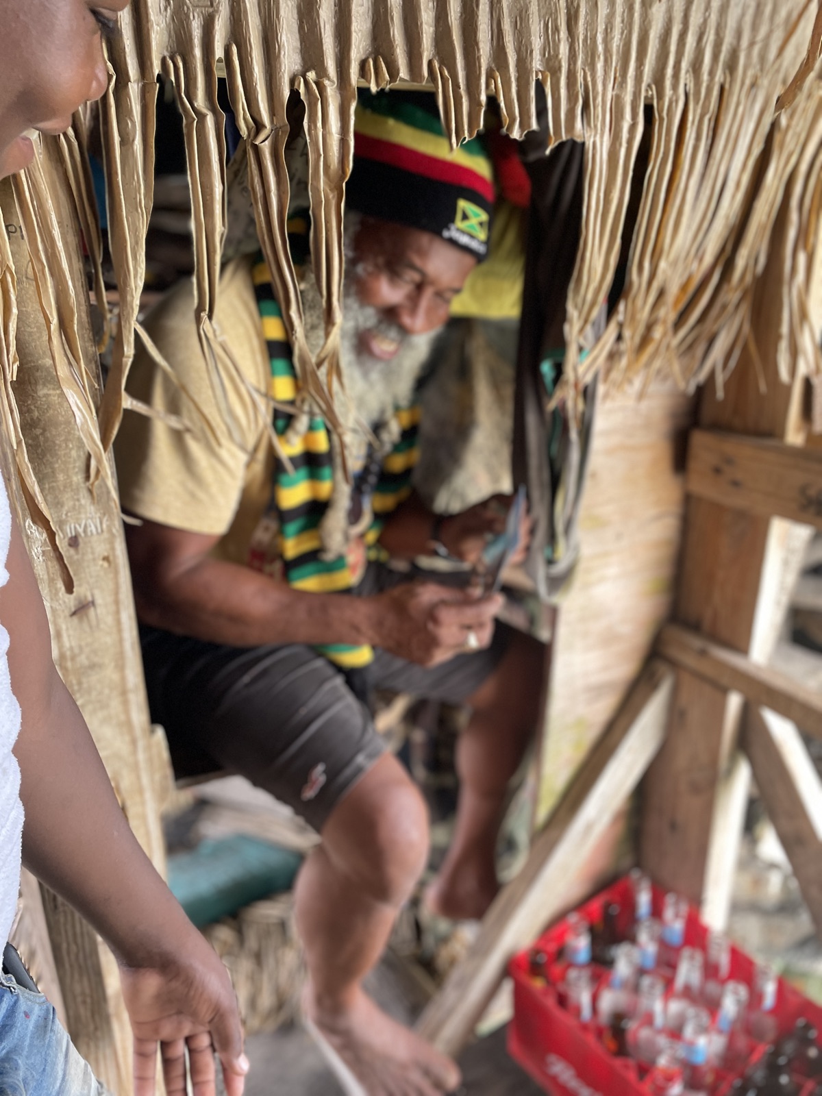 Floyd Forbes, owner of Floyd's Pelican Bar, in a Rasta hat and Jamaica-flag colors inside the bar