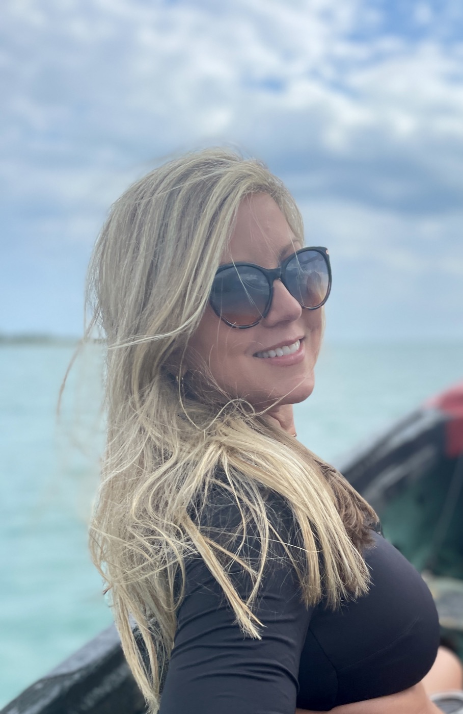 Karen on the boat out to Floyd's Pelican Bar, the turquoise Caribbean sea behind her