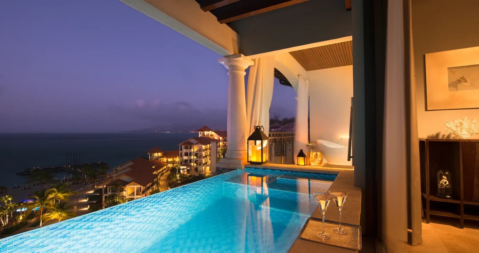 Skypool Suite at Sandals Grenada at dusk, its infinity plunge pool cantilevered off the balcony above the bay