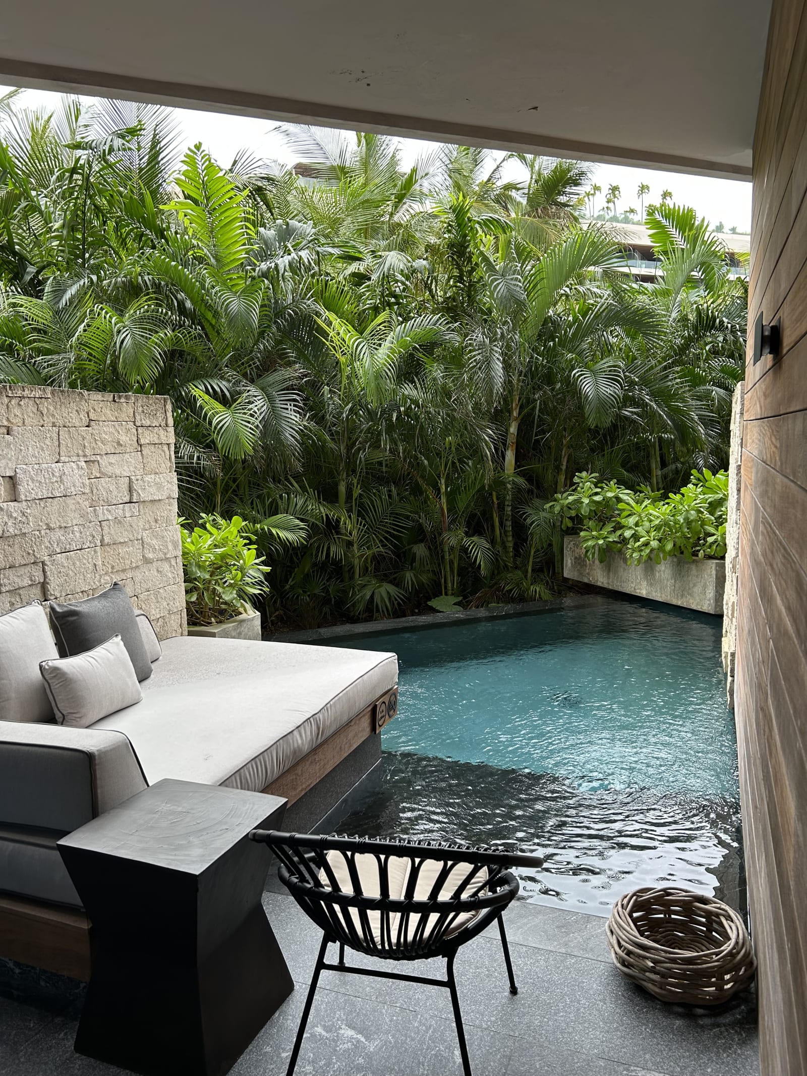 Preferred Club swim-out suite at Secrets Moxché, with a daybed on the terrace beside its own walled pool, screened by stone and timber with jungle planting behind