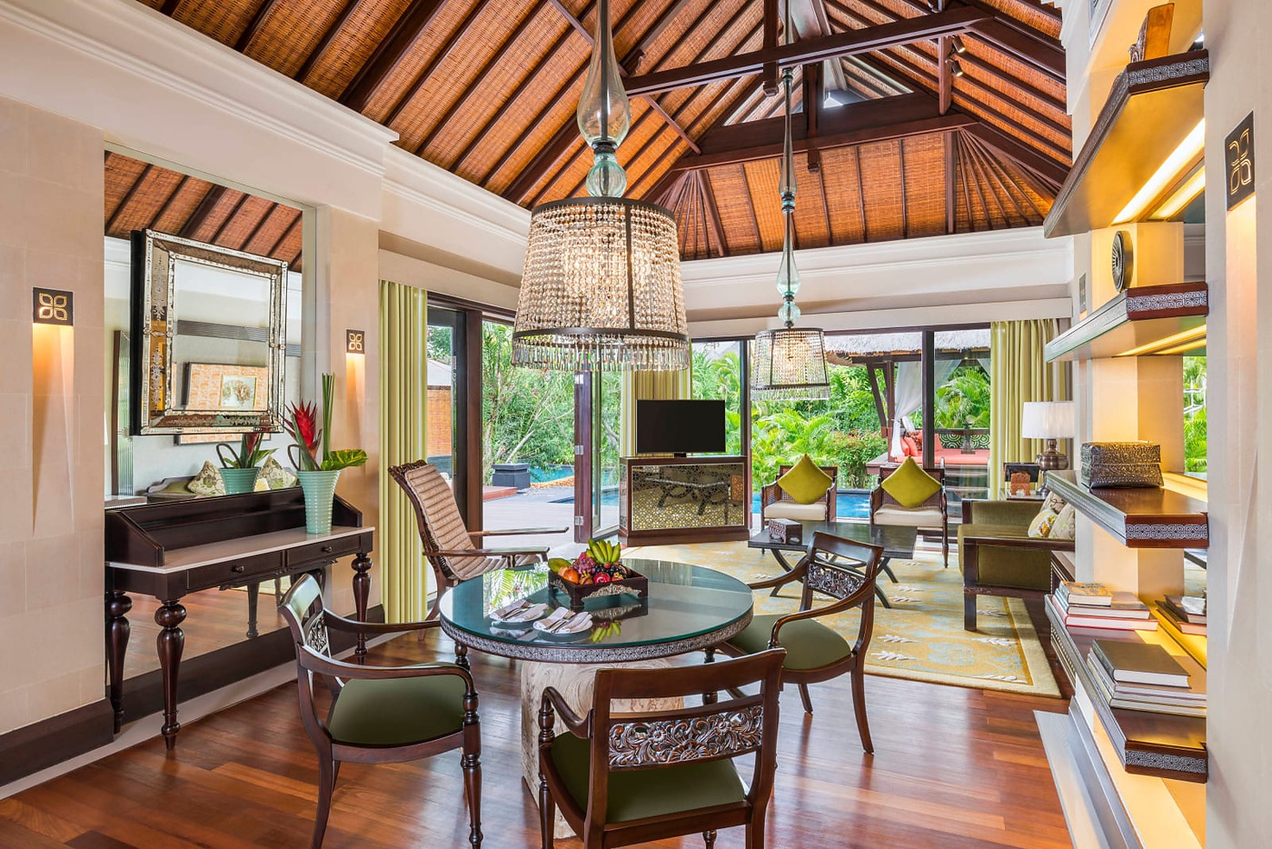 Interior of a Lagoon Villa at The St. Regis Bali, under a high thatched ceiling, with glass doors opening onto the villa's own pool
